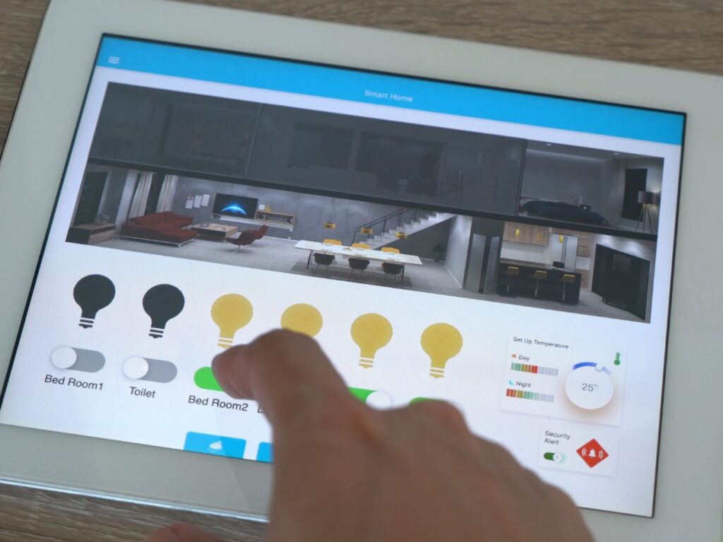 a smart lighting system. A finger swiping on a tablet that is displaying different light bulb toggle switches