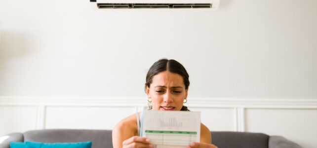 woman holding an energy bill and frowning